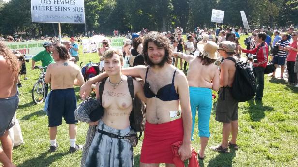 A young couple show their support for women's rights to be topless on Sunday, Aug. 24 at Mont-Royal park in Montreal.