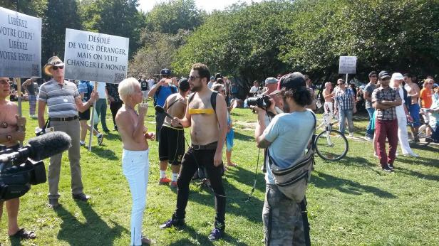 Sylvie Chabot is interviewed by a media person who shows his support by taping over his breasts at Sunday's demonstration in support of women's rights to be topless in public. (Photo by Jillian Page exclusively for jillianpage.com. No other reproduction permitted.)